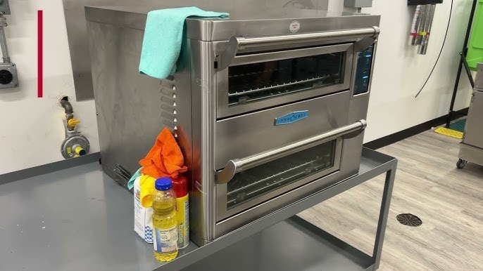 Grease and food debris buildup inside the metal cavity of a speed oven.